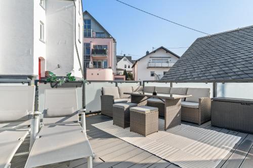 a patio with chairs and tables on a balcony at HOMEBASE - Design Lofts am Schloss in Montabaur