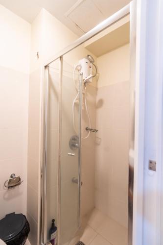 a shower with a glass door in a bathroom at BreezeVista Getaway in Kaybagal