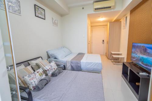a bedroom with a bed and a flat screen tv at BreezeVista Getaway in Kaybagal