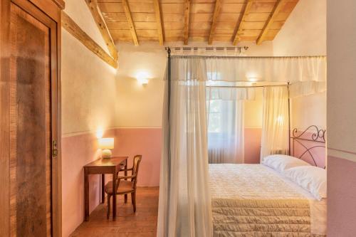 a bedroom with a bed and a table and a desk at Podere Lamone a Monticchiello in Monticchiello