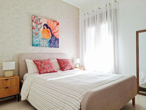 a bedroom with a bed and a painting on the wall at Muy acogedor, a 5 min a pie del centro, Cama 1'60, Wifi y Netflix in San Vicente de la Barquera