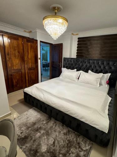 a large bed in a bedroom with a chandelier at Afraah guest house in Yaoundé