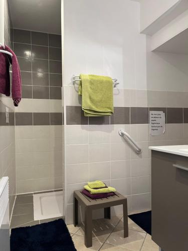 a bathroom with a shower with a table and yellow towels at Grand Mainguet in Saint-Lambert-la-Potherie