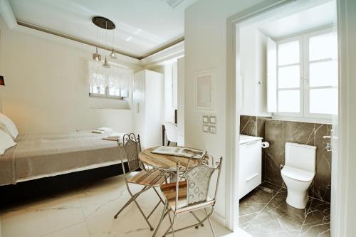 a bedroom with a bed and a table and a toilet at Earino apartments in Hydra