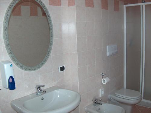 La salle de bains est pourvue d'un lavabo, de toilettes et d'un miroir. dans l'établissement Hotel Ristorante Lepanto, à Salò