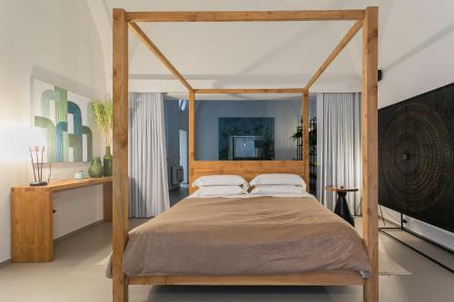 a bedroom with a wooden canopy bed with two pillows at Suite 1926 Luxury Room in Triggiano