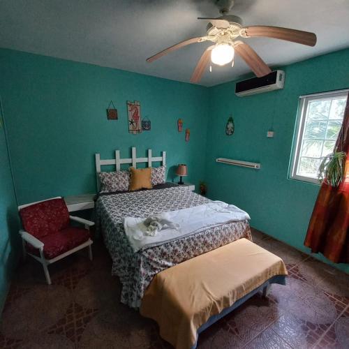 a bedroom with a bed and a ceiling fan at Fisherman's Inn Hotel Silver Sands, Duncans Bay in Duncans