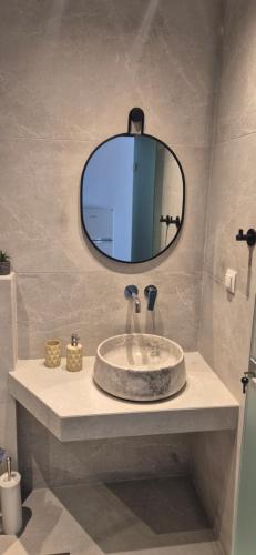 a bathroom with a sink and a mirror at Petrino 2 by Vasileia in Sarti