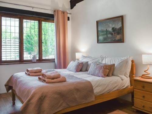 a bedroom with a bed with two towels on it at Byre Cottage - Uk50028 in Liskeard