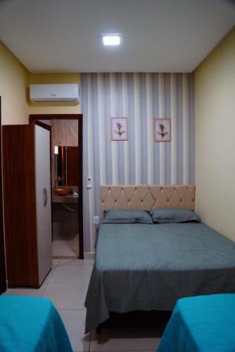 a bedroom with a bed with a green bedspread at Village vila verde in Itaitu