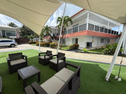a group of chairs and tables on a lawn in front of a building at Hotel Mar de Corales By CAJASAI in San Andrés