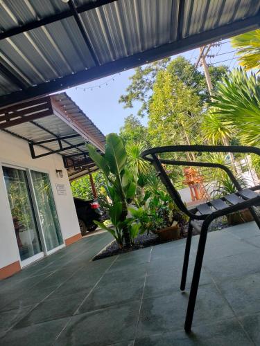 a black chair sitting on a patio in front of a building at บ้านสวนริมทาง in Ban Pha Saeng Lang
