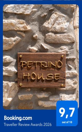 a sign on the side of a stone wall at Petrino House in Apérathos