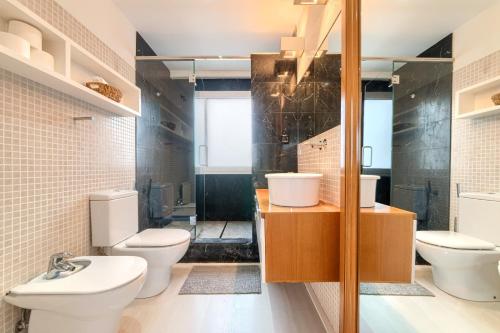 a bathroom with two toilets and a shower at Apartamento Bilbao Aeropuerto - Derio in Derio