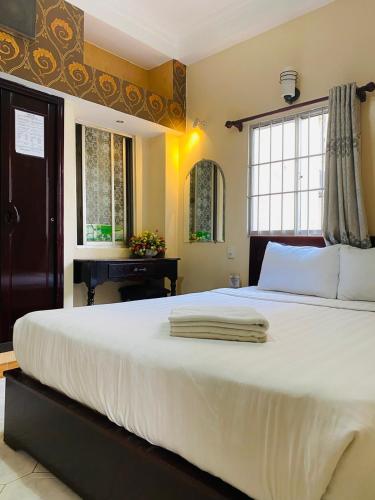 a large white bed in a bedroom with a piano at Heaven Hostel in Ho Chi Minh City