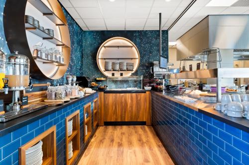 a large kitchen with blue tiles and a counter at Waterstate Wellness hotel Goes in Goes