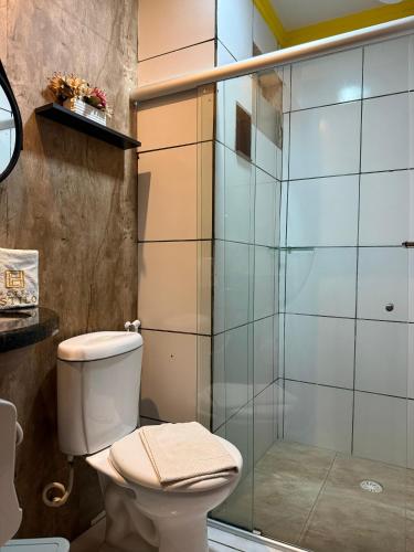 a bathroom with a toilet and a glass shower at Hotel Estilo in Arapiraca