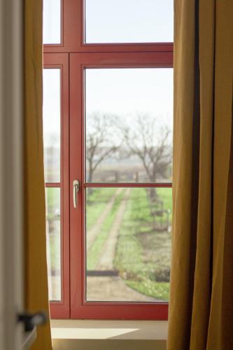 a window with a view of a field through it at De Snippe in Damme