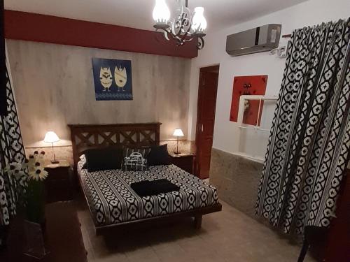 a bedroom with a bed with a black and white comforter at La Casa de Mia Mama in Salta
