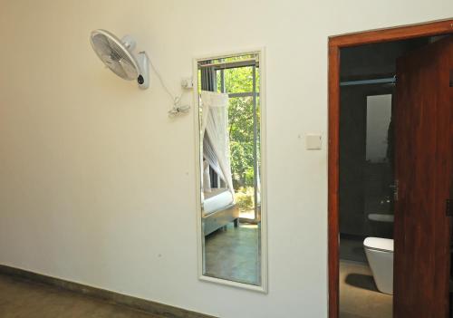 a mirror on a wall next to a bathroom at Kithal Ella Station Resort in Ella