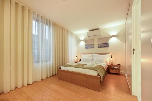 a bedroom with a bed and a large window at ON Apartments - MA62 Downtown in Porto