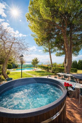a hot tub in a backyard with a table and chairs at Casa La Vega in Colmenar de Oreja