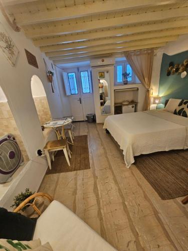 a large bedroom with a bed and a table at Capparis Studio in Mikonos