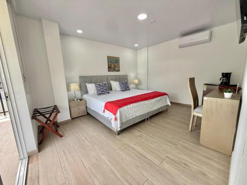 a bedroom with a bed and a table and a chair at Hotel Mar de Corales By CAJASAI in San Andrés