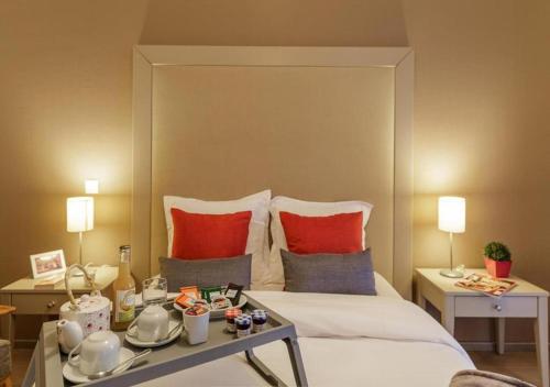 a hotel room with a large bed with red pillows at Zenao Appart'hôtels Strasbourg in Strasbourg