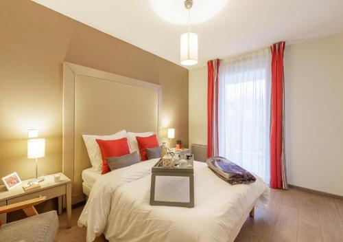 a bedroom with a large bed with a table on it at Zenao Appart'hôtels Strasbourg in Strasbourg