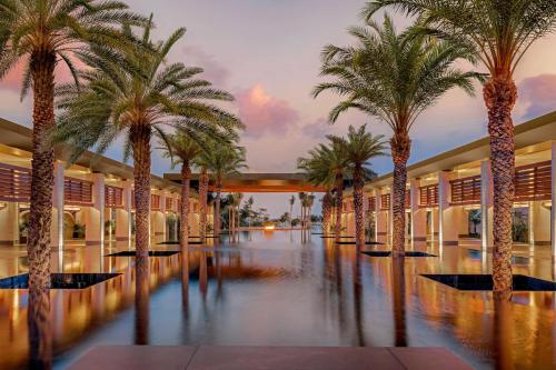 a corridor with palm trees in a building at Conrad Tulum Riviera Maya in Tulum
