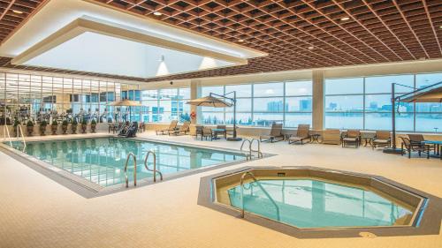 Una gran piscina en un edificio con mesas y sillas. en Caesars Windsor, A Caesars Destination, en Windsor