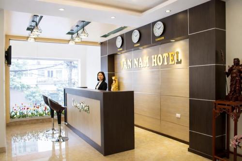 a woman standing at a counter in a hotel lobby at Vân Nam Hotel in Cao Bằng
