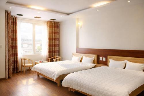 a hotel room with two beds and a window at Vân Nam Hotel in Cao Bằng