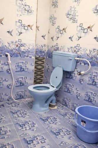 a bathroom with a blue toilet and a tub at Elite Castle Stay in Kottakupam