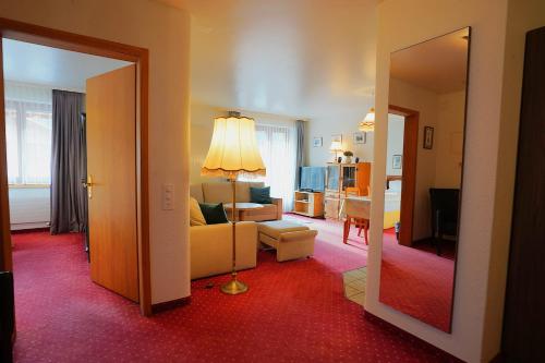 a living room with a couch and a room with a mirror at Chalet Miravalle 2 in Wengen