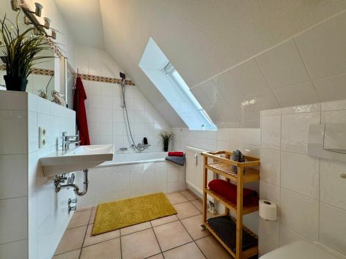 a bathroom with a sink and a bath tub at Oewern Diek App 09 in Wustrow