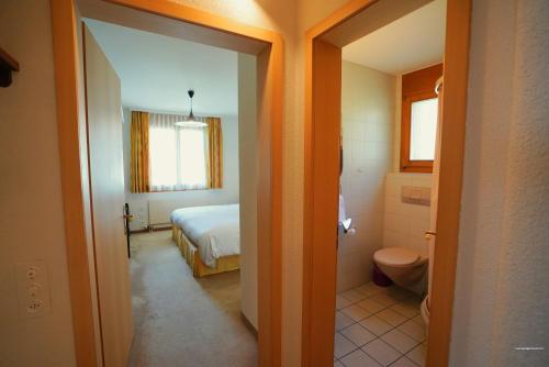 a bedroom with a bed and a bathroom with a toilet at Chalet Miravalle 3 in Wengen