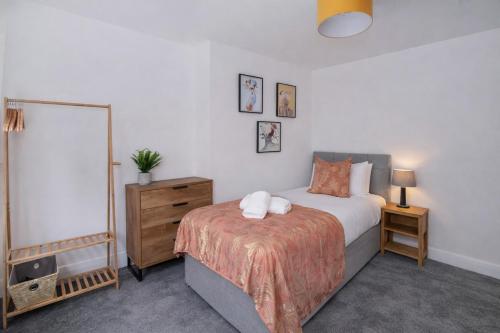 a bedroom with a bed and a dresser and a mirror at Stylish Hot Tub House with free parking! in York