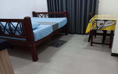 a small bedroom with a bed and a table at Sanda Villa Dodanduwa in Dodanduwa