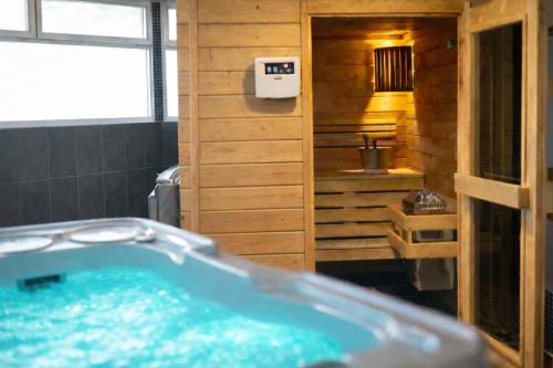 a bathroom with a tub in a wooden bathroom at Hotel Europa in Quiberon