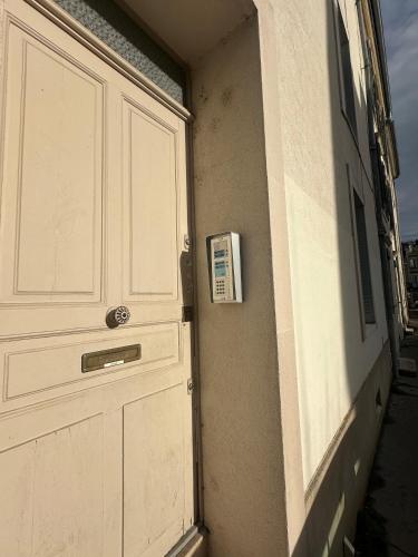 a garage door with a sign on it next to a building at Hôtel des Cousines Capucine Apartment in Nancy