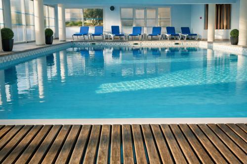 a swimming pool with blue chairs in a hotel at Hotel Europa in Quiberon
