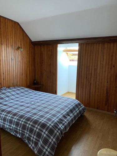 a bedroom with a bed with a plaid blanket at Chalet Masana in Murat-le-Quaire