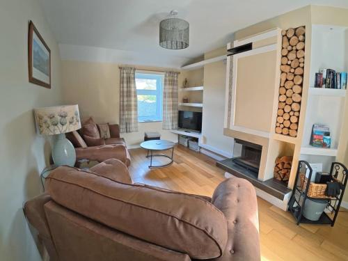 a living room with a couch and a fireplace at Jessamine Cottage in Blairgowrie