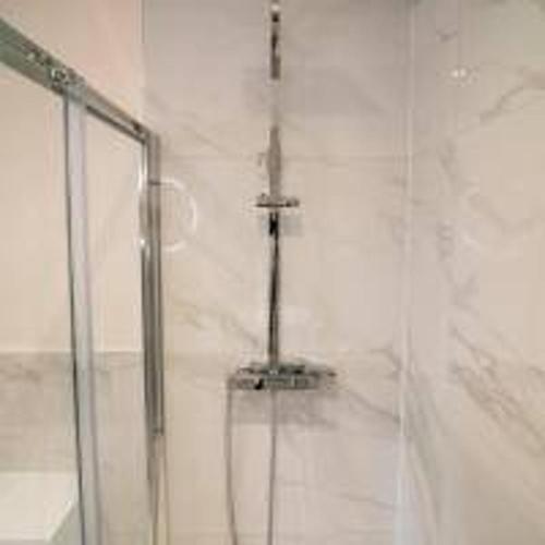 a shower with a glass door in a bathroom at Foundry Farm Cottage in Hexham