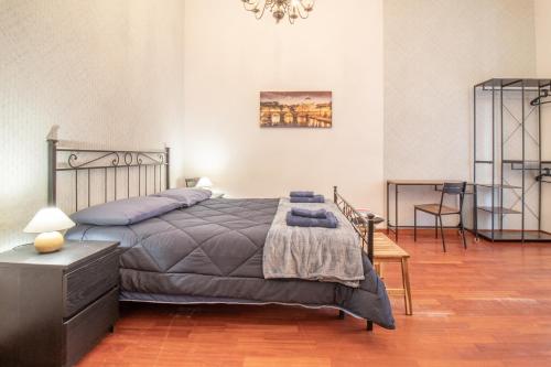a bedroom with a bed and a table and a chandelier at Long John Apartment in Rome