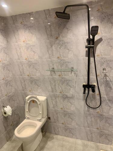 ein Badezimmer mit Toilette und Dusche in der Unterkunft Perry Hills Apartment in Weija