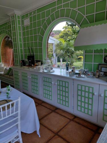 a green room with a white counter and an archway at 18 Pioneer BnB in Kloof