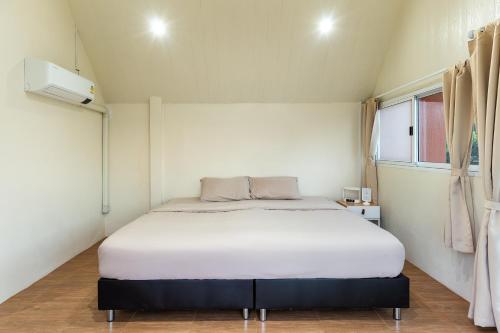 a bedroom with a white bed in a room at PATTA Hideaway Chiang Dao in Chiang Dao